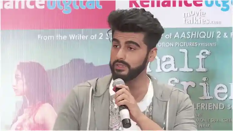 Arjun Kapoor looking at a reporter with a firm expression during the Half Girlfriend press meet, Shraddha Kapoor seated beside him