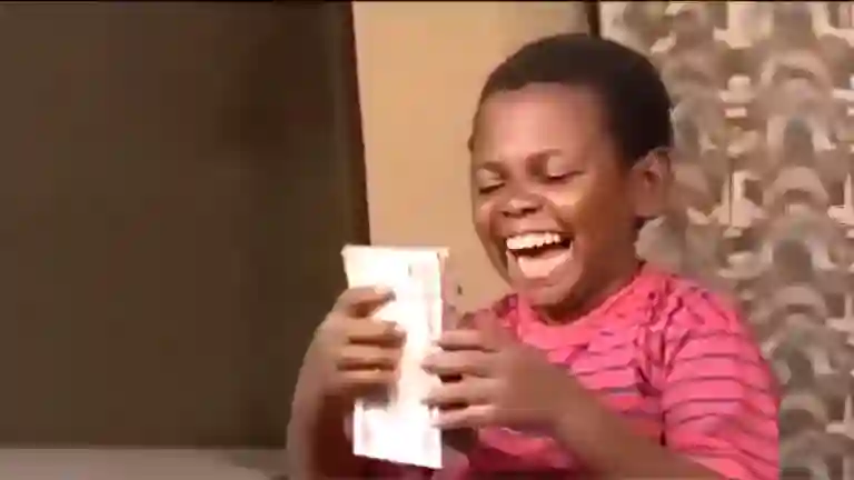African boy smiling with joy after saying I’m rich in the viral meme clip