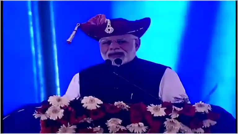 Prime Minister Narendra Modi speaking at a podium with a raised hand during the 2019 Silvassa rally